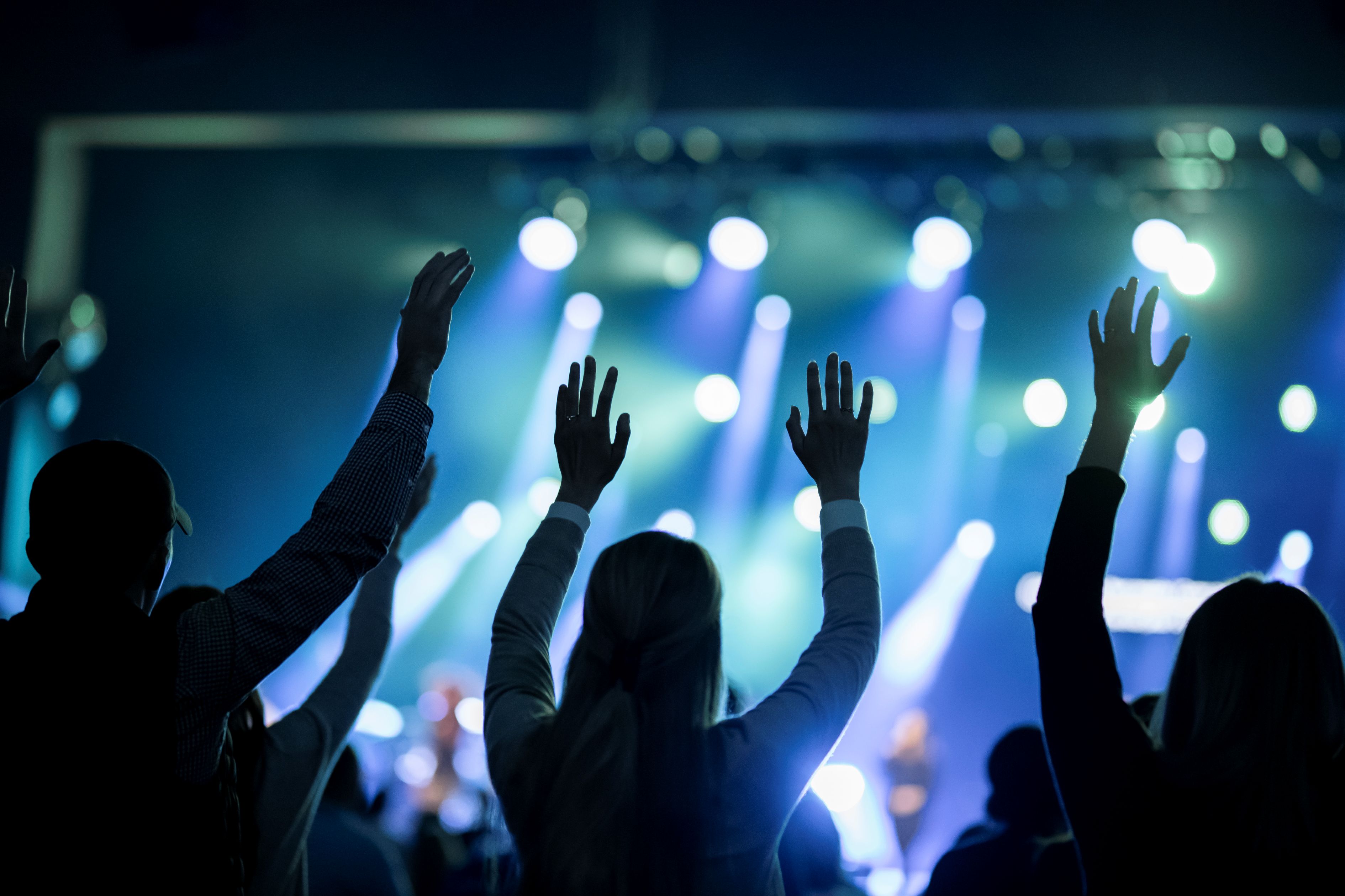 Mujeres en una multitud con las manos en alto