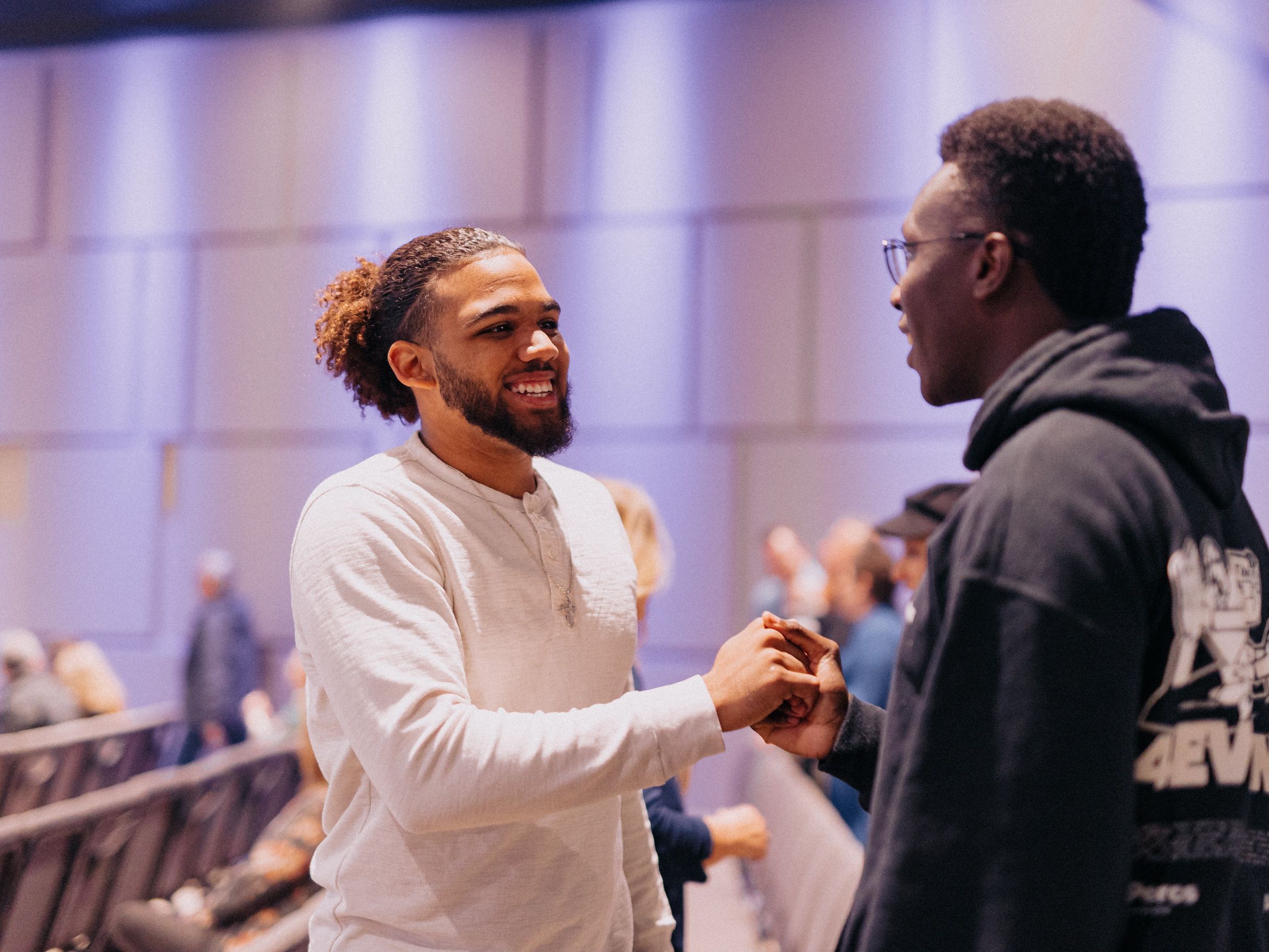 Dos hombres se dan la mano y sonríen