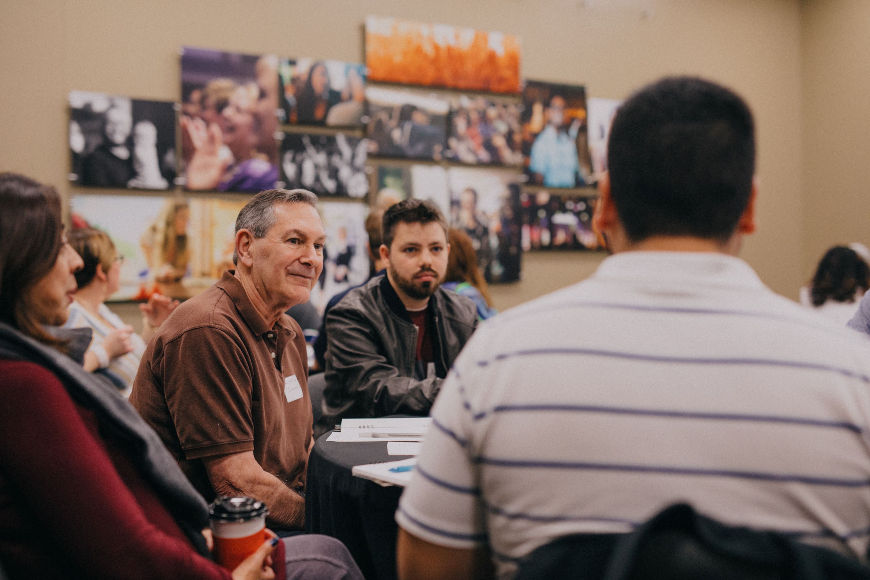 Group of people sitting at a table looking at each other