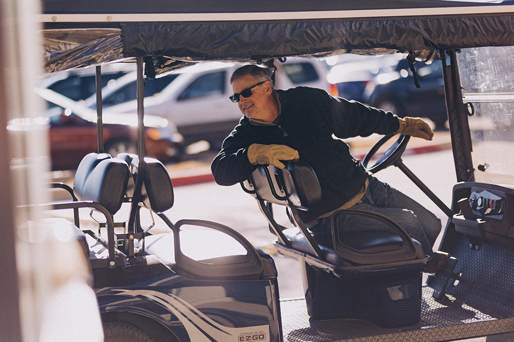 Hombre dando marcha atrás a un carrito de golf